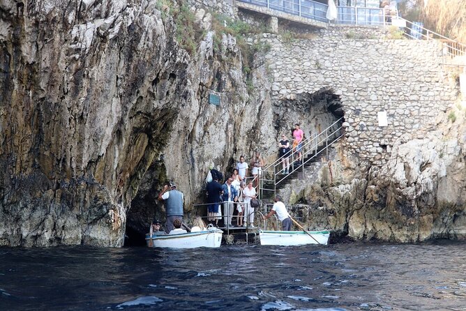 Capri & Blue Grotto: Full-Day Tour with Guided Island Exploration - Entering the Blue Grotto by small wooden boat