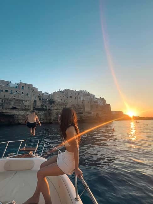 Polignano: Guided Coastline & Caves Cruise with Swim Break - The Domenico Modugno monument from offshore